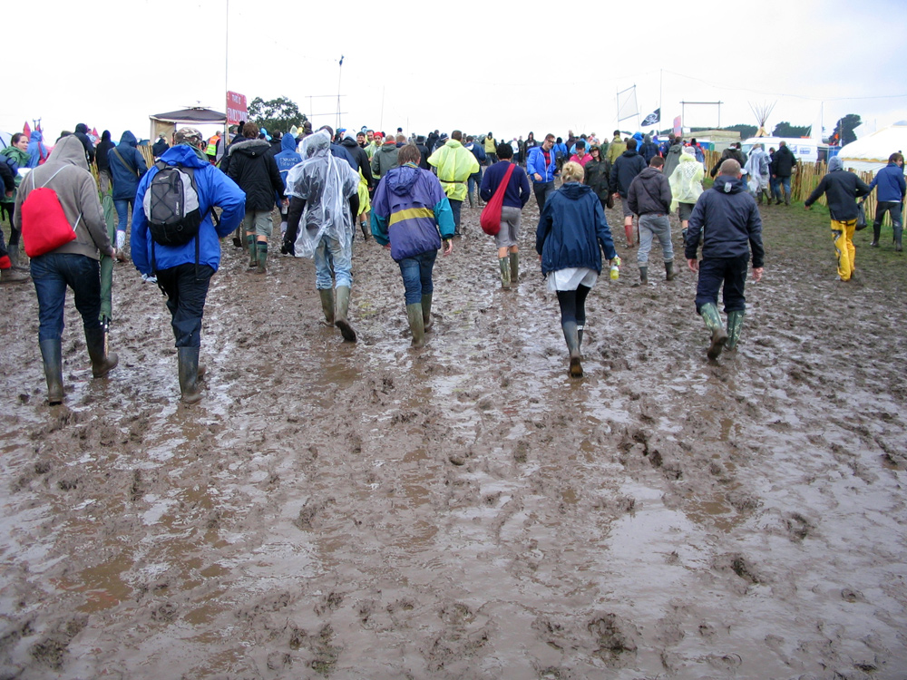 Fotografía que muestra varias personas caminando en el lodo